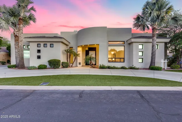 a front view of a house with a garden and a tree