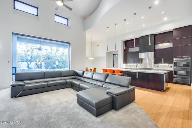 a large kitchen with stainless steel appliances kitchen island granite countertop a table chairs sink and cabinets