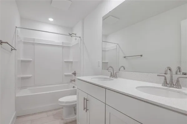 a bathroom with a granite countertop sink a toilet and shower