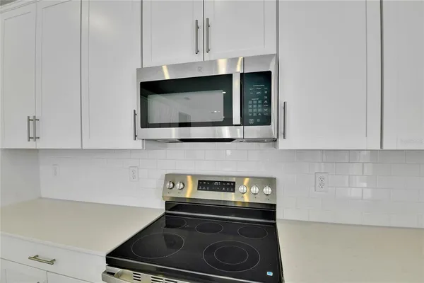 a kitchen with stainless steel appliances granite countertop a stove a microwave and cabinets