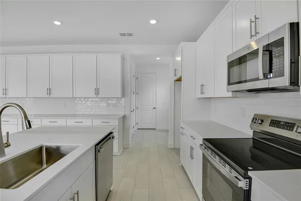 a kitchen with stainless steel appliances granite countertop a sink stove and microwave