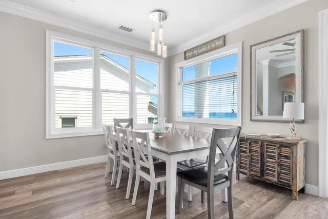 a dining room with furniture a chandelier and wooden floor