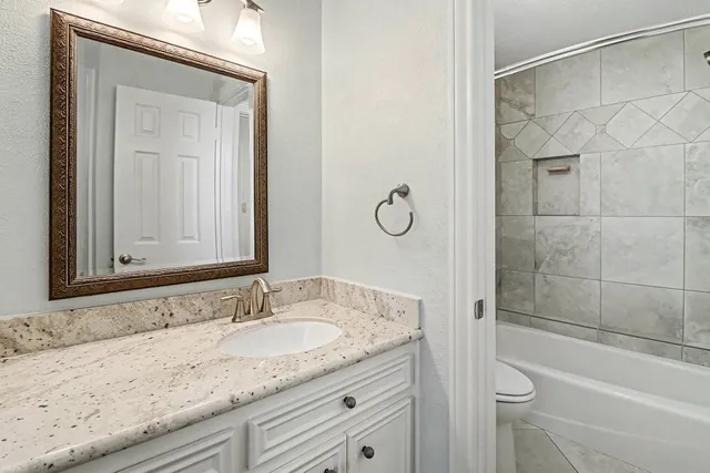 a bathroom with a granite countertop sink mirror and vanity