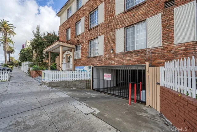 a view of a brick house with iron fence
