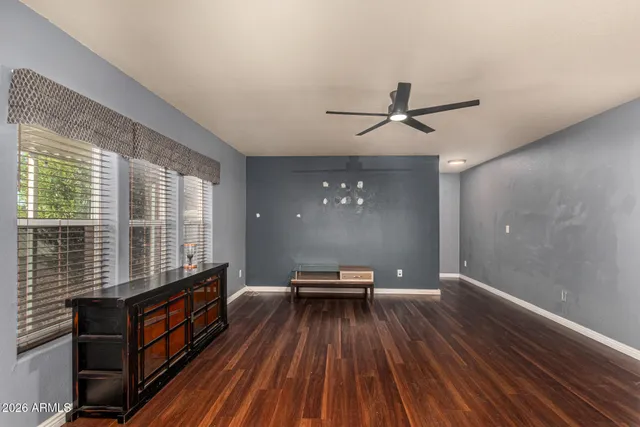 a view of a room with furniture wooden floor and a ceiling fan