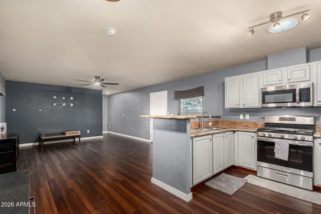 a kitchen with stainless steel appliances kitchen island granite countertop a stove a sink and a microwave