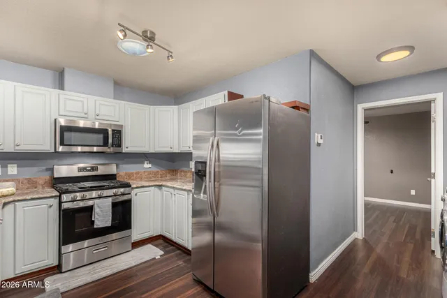 a kitchen with stainless steel appliances a refrigerator sink and microwave