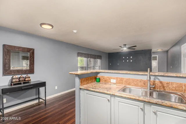 a kitchen with a sink and a wooden floor