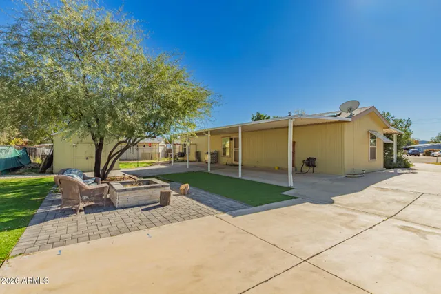 a view of a house with backyard and a tree