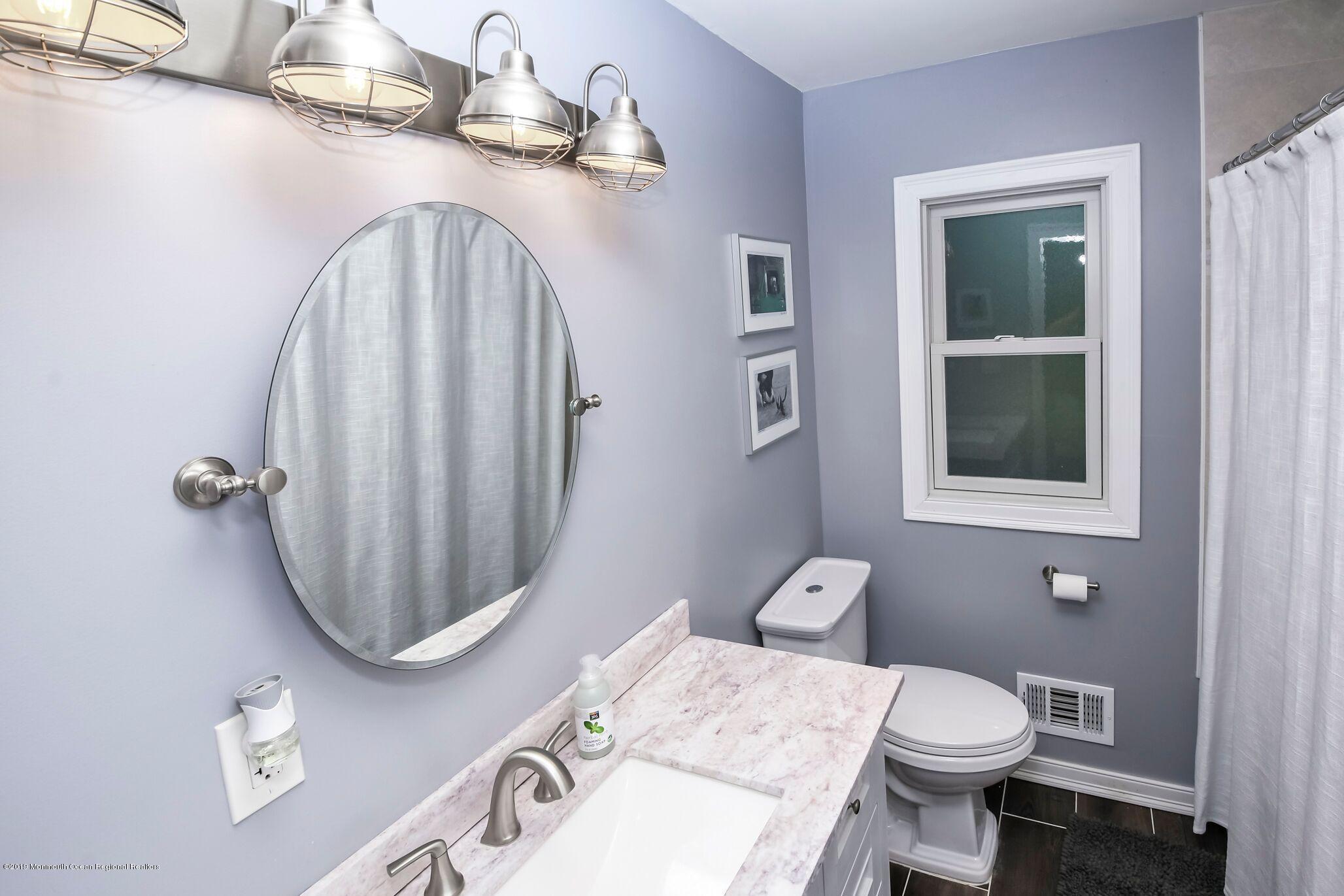 76 Bruce Road Red Bank, NJ 07701 - Photo 19 of 24 a bathroom with a granite countertop toilet a sink and mirror