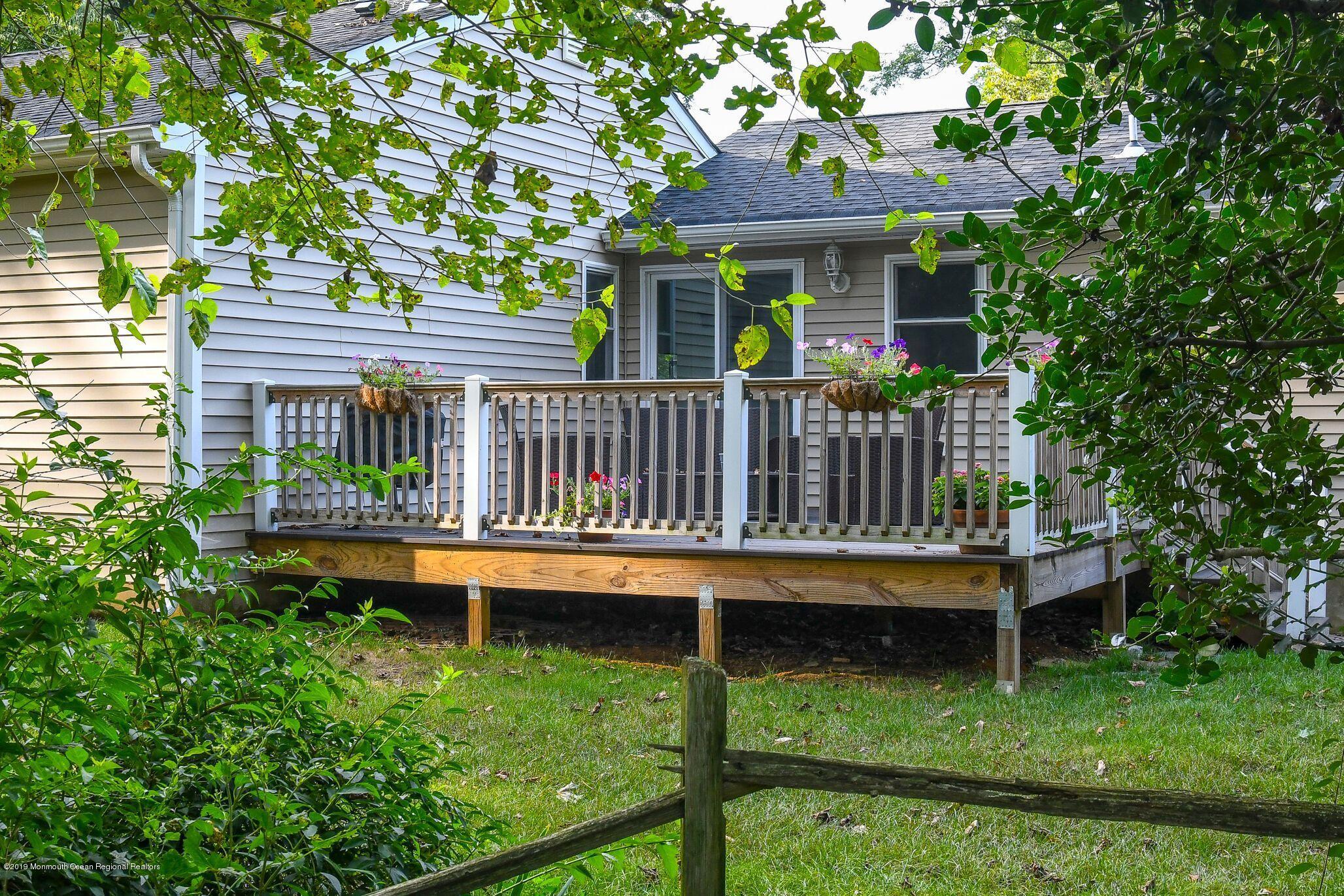 76 Bruce Road Red Bank, NJ 07701 - Photo 21 of 24 a view of a wooden deck and a yard with a fountain