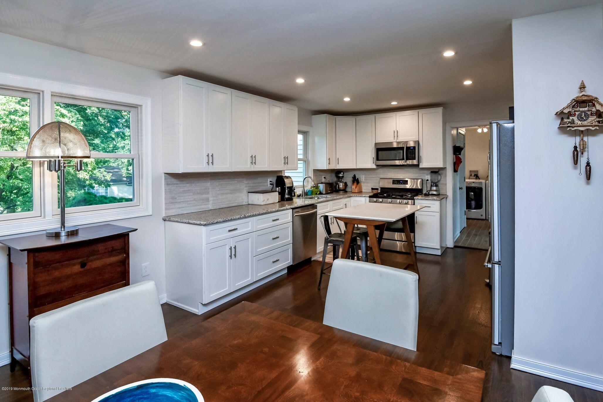 76 Bruce Road Red Bank, NJ 07701 - Photo 9 of 24 a kitchen with stainless steel appliances granite countertop a stove top oven a sink a refrigerator white cabinets and wooden floor
