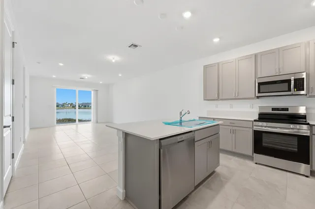 a kitchen with stainless steel appliances granite countertop a stove a sink and a microwave