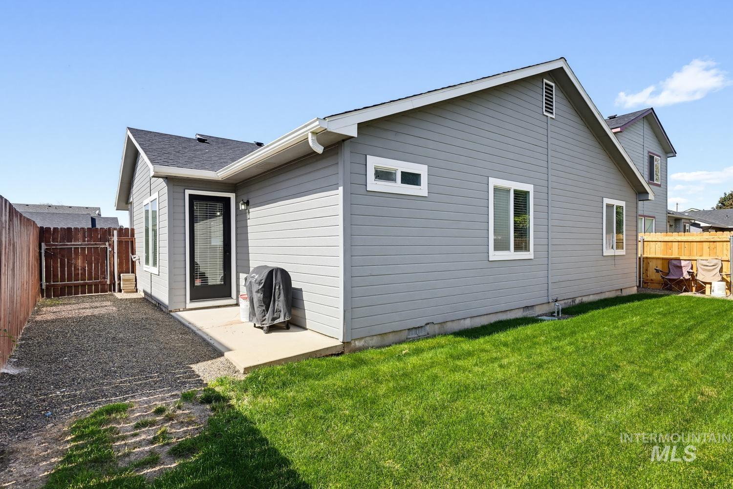 5221 Lockwood Way Caldwell, ID 83607 - Photo 23 of 27 Manicured lawn with a gravel area, wood fencing, and a concrete patio
