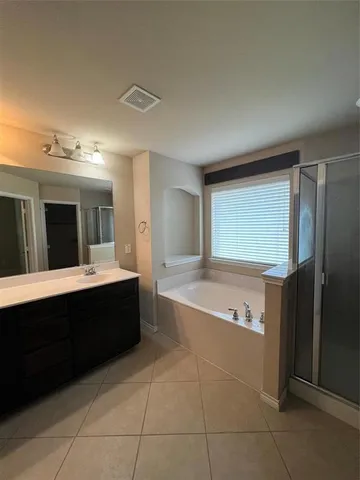a spacious bathroom with a bathtub shower and sink