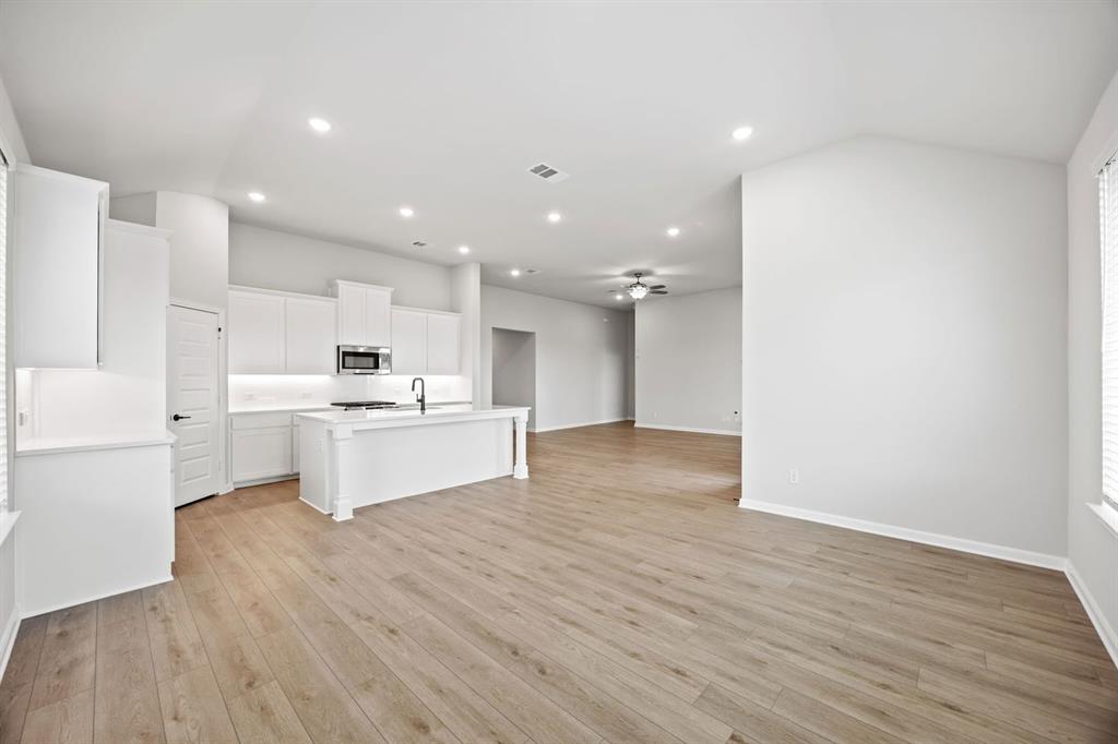 1422 Red Clover Avenue Van Alstyne, TX 75495 - Photo 11 of 30 a large white kitchen with kitchen island a sink white cabinets and wooden floor