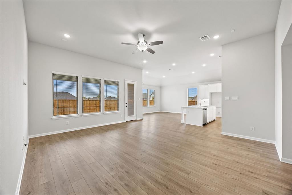 1422 Red Clover Avenue Van Alstyne, TX 75495 - Photo 7 of 30 a view of an empty room with a window and wooden floor