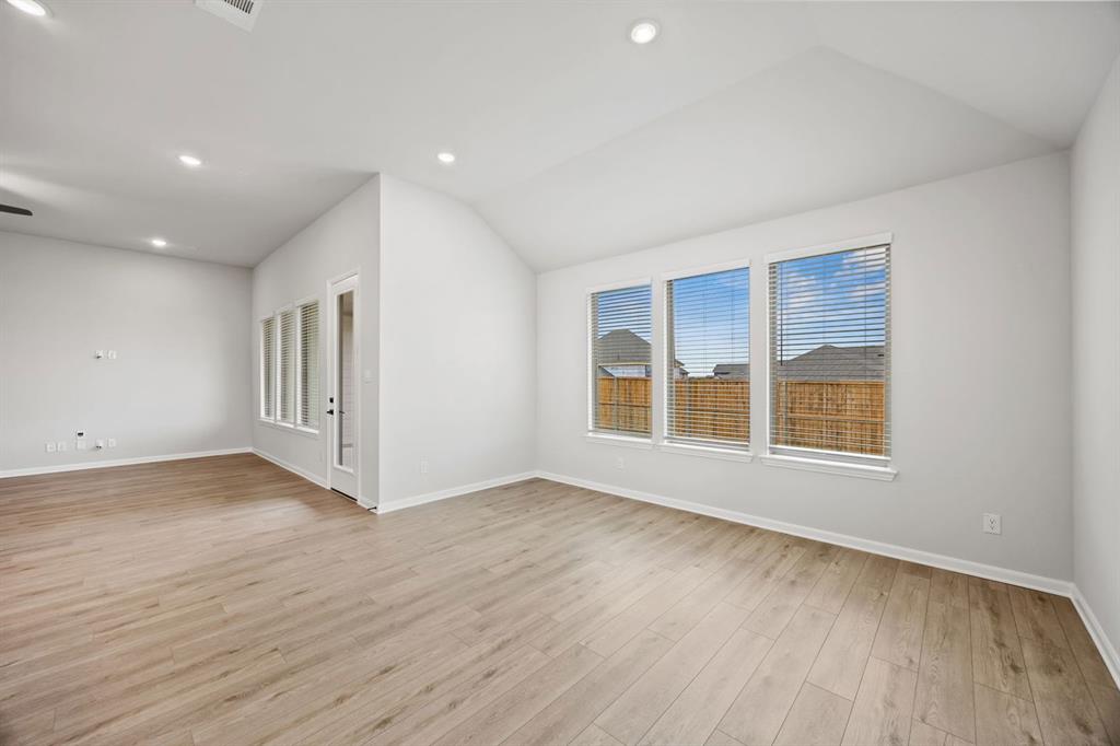 1422 Red Clover Avenue Van Alstyne, TX 75495 - Photo 9 of 30 a view of an empty room with wooden floor and a window