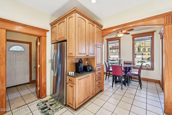a dining room with stainless steel appliances kitchen island granite countertop a refrigerator and a sink