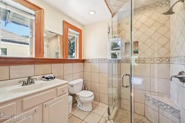 a bathroom with a sink a toilet and a mirror