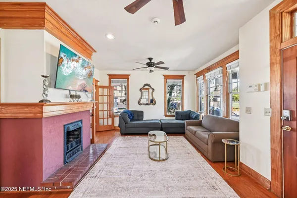 a living room with furniture a fireplace and a large window