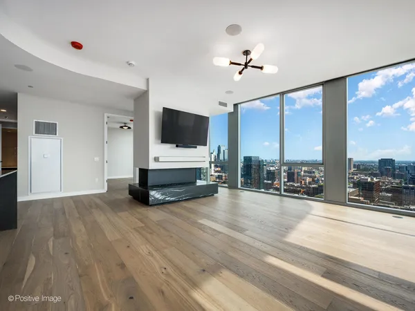 a view of livingroom with furniture flat screen tv and floor to ceiling window
