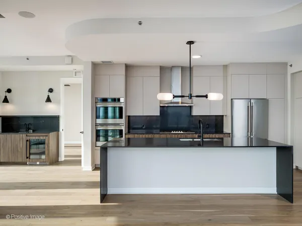 a kitchen with kitchen island a counter top space appliances and cabinets