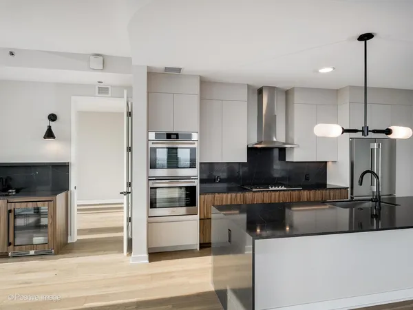 a kitchen with stainless steel appliances granite countertop a refrigerator a sink and a stove