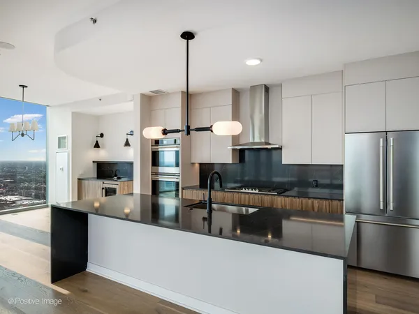 a kitchen with a sink a counter top space and stainless steel appliances