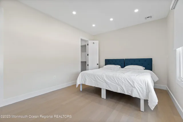 a spacious bedroom with a bed and a night stand