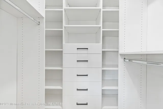 a view of walk in closet with empty racks