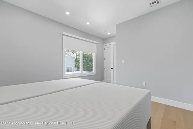 a large white bed in a room next to a window