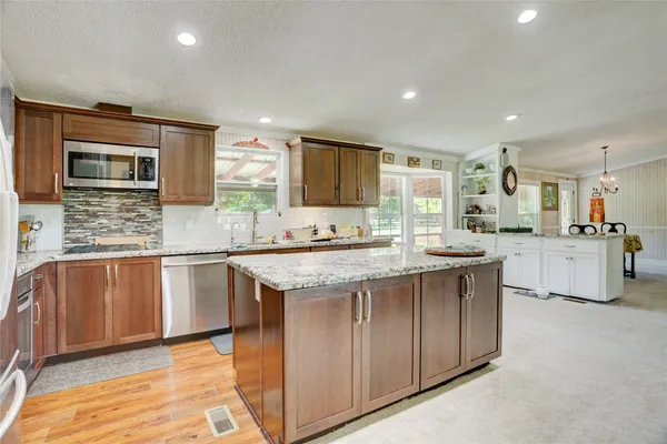 a kitchen with stainless steel appliances granite countertop a sink stove and cabinets