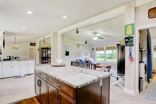 a kitchen with granite countertop kitchen island stainless steel appliances a sink stove and refrigerator