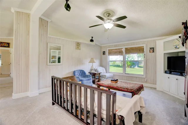 a view of a livingroom with furniture window and a ceiling fan