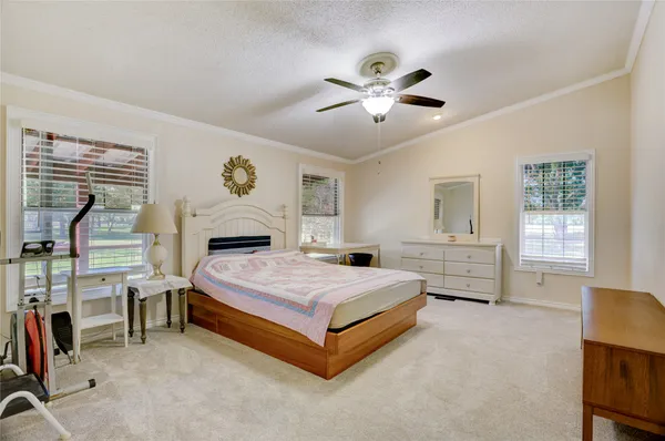 a spacious bedroom with a bed and a chandelier