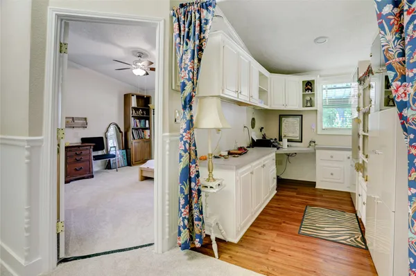 a kitchen with cabinets and wooden floor