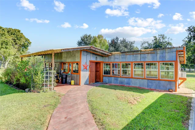 a view of a house with a yard and sitting area