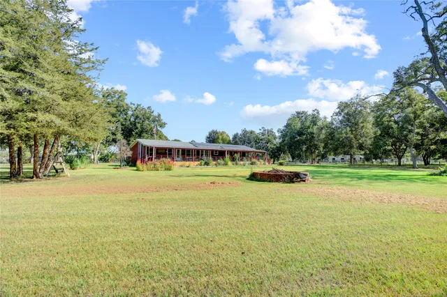 a view of a swimming pool with lawn chairs under an umbrella