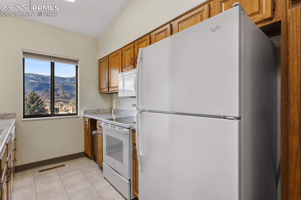 1130 Fontmore Road, Unit C Colorado Springs, CO 80904 - Photo 12 of 27 a kitchen with a refrigerator and a stove top oven