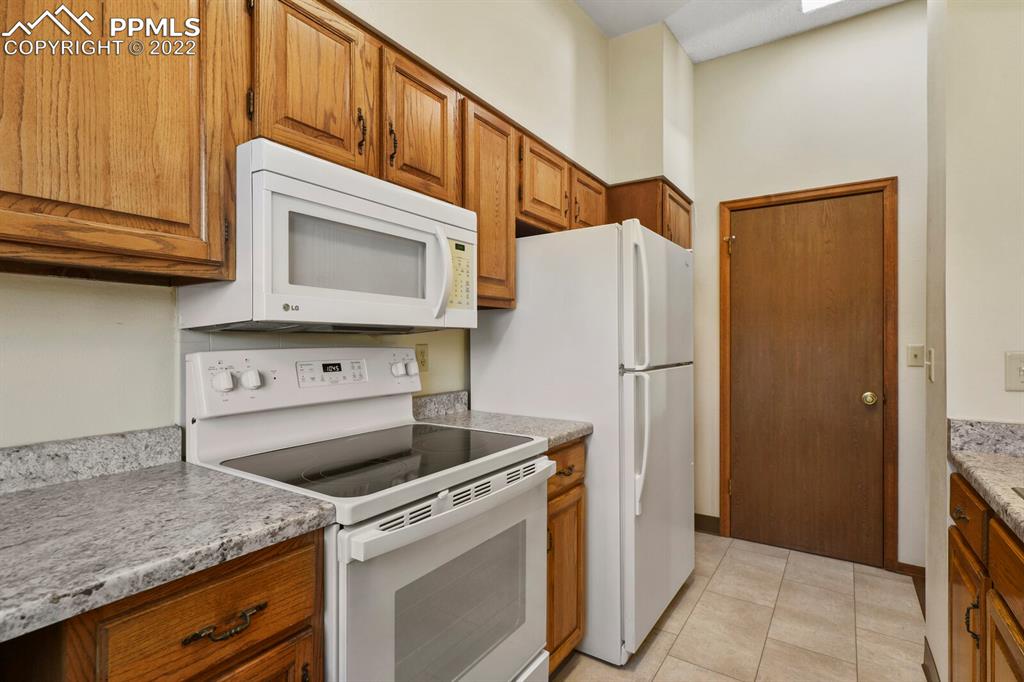 1130 Fontmore Road, Unit C Colorado Springs, CO 80904 - Photo 15 of 27 a kitchen with granite countertop white cabinets and stainless steel appliances