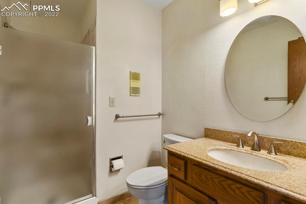 1130 Fontmore Road, Unit C Colorado Springs, CO 80904 - Photo 17 of 27 a bathroom with a granite countertop sink toilet and a mirror