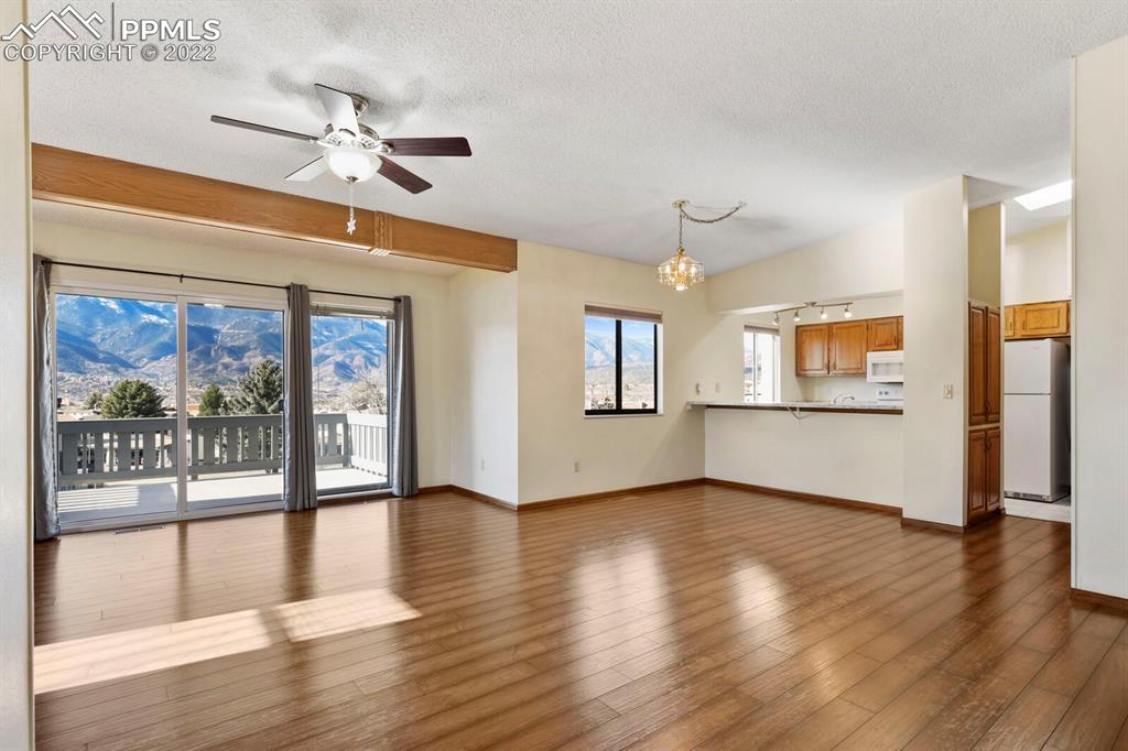 1130 Fontmore Road, Unit C Colorado Springs, CO 80904 - Photo 5 of 27 a view of a livingroom with wooden floor a ceiling fan and windows