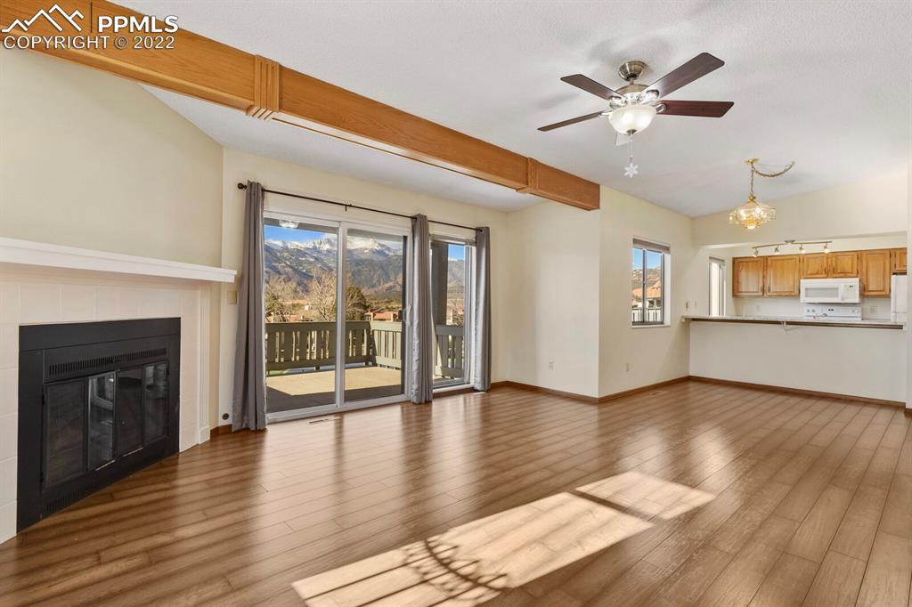 1130 Fontmore Road, Unit C Colorado Springs, CO 80904 - Photo 7 of 27 an empty room with wooden floor and fireplace