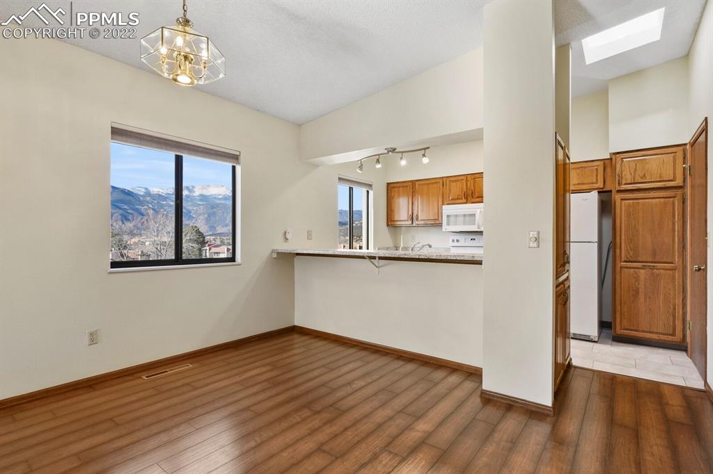 1130 Fontmore Road, Unit C Colorado Springs, CO 80904 - Photo 9 of 27 a view of a hallway with wooden floor and a kitchen