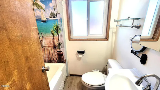 a bathroom with a toilet and a shower curtain