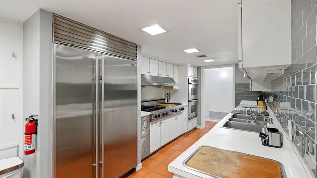 a kitchen with kitchen island a sink stainless steel appliances and cabinets