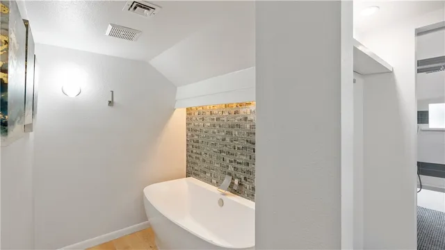 a bathroom with a tub sink and mirror
