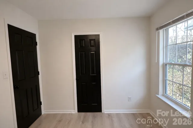 a view of an empty room with windows and closet
