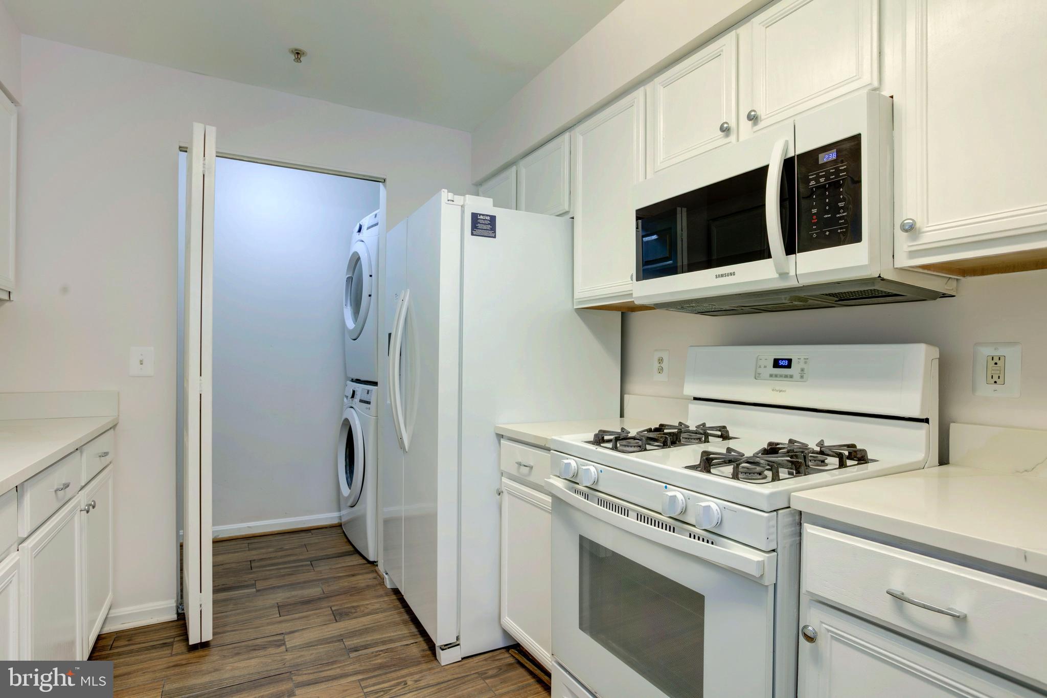 14174 Cuddy Loop, Unit 204 Woodbridge, VA 22193 - Photo 11 of 24 a kitchen with stainless steel appliances a stove a microwave and a refrigerator